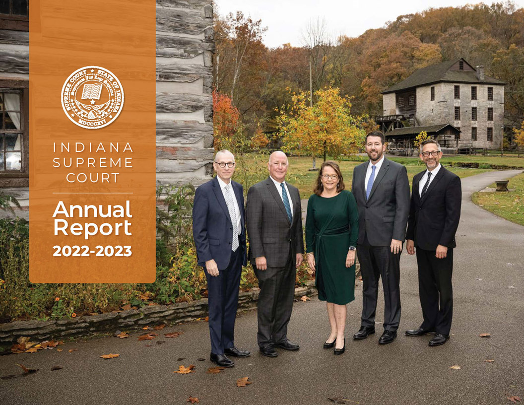 Indiana Supreme Court, Annual Report 2022-2023 cover with the five justices standing in business attire on a park trail with the old mill at Spring Mill State Park in the distance.