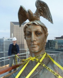 Victoria Emery measures up to Victory sculpture. Courtesy Arsee Engineers 