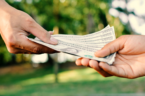 Hand giving money to another hand