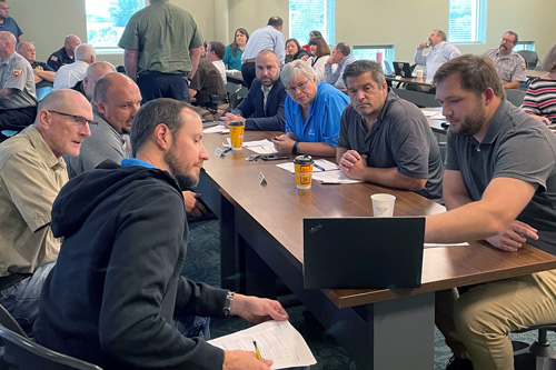 Group looks at laptop on table