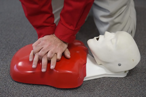 Hands pressing on chest of CPR dummy