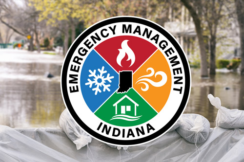 Emergency management logo over flooded roadway with sandbags