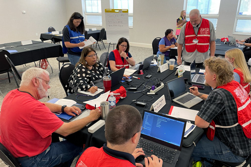 EOC personnel discuss tasks around table