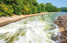 Indiana conservation officers maneuver against the swift current of the Mississinewa River just below the dam at Mississinewa Lake in Peru. 