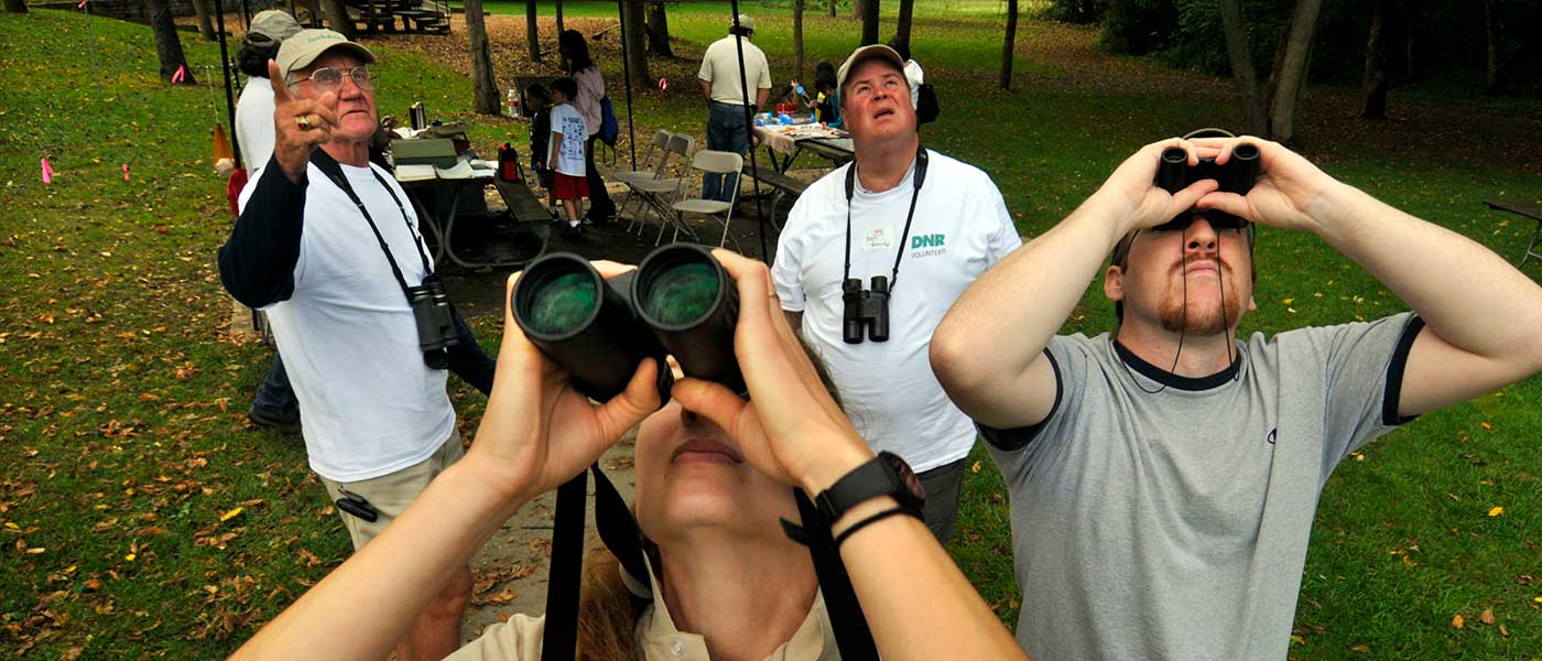 People with binoculars looking up