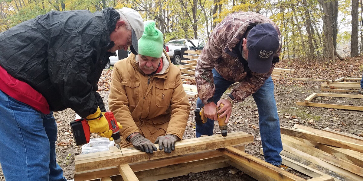 Two men working on a board