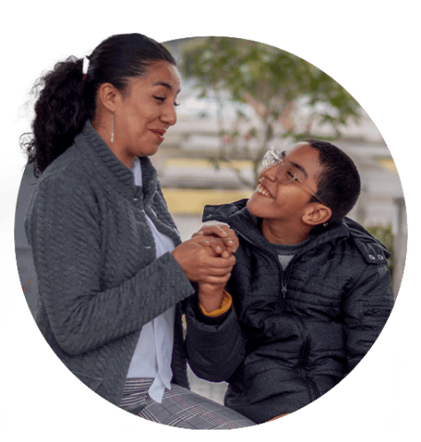 Mother talking to son while holding his hand.
