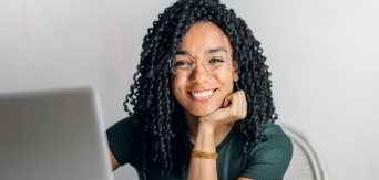 Young woman smiling while working at a computer.