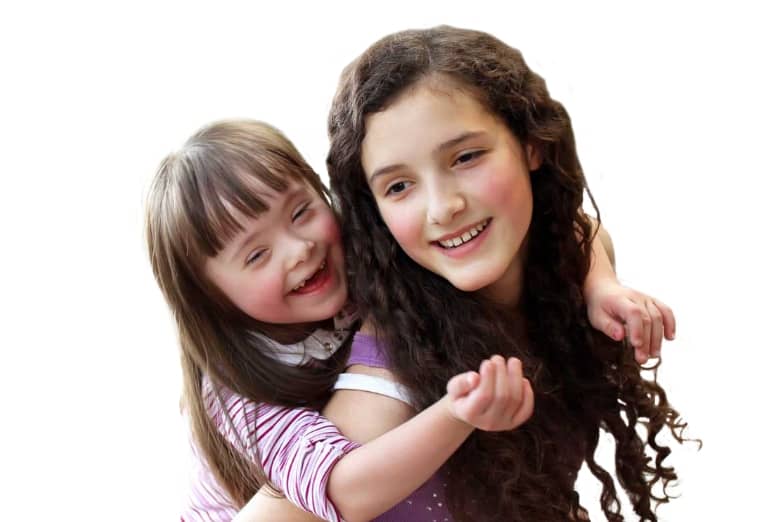 Young girl carrying toddler on her back.